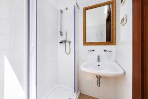 a white bathroom with a sink and a mirror at Casa Natura Gargano in Monte SantʼAngelo +80 photos