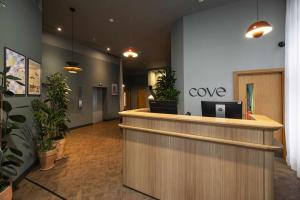 an office lobby with a reception counter and potted plants at Cove Minshull Street in Manchester