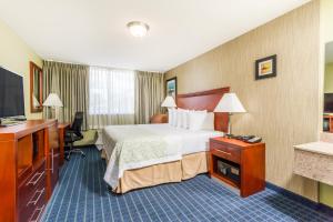 a hotel room with a bed and a flat screen tv at Days Inn by Wyndham Windsor Locks / Bradley Intl Airport in Windsor Locks
