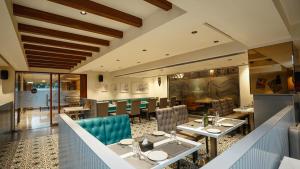 a dining room with tables and chairs in a restaurant at Hotel Heritage Grand in Thane