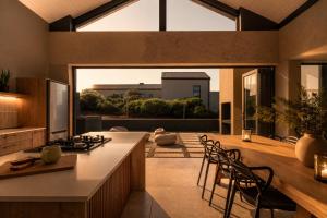 a kitchen with a counter and chairs in a room at 401 Kingfisher in Gansbaai