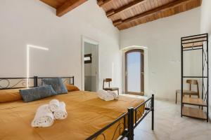 a bedroom with a large bed with towels on it at Sikania Agrirelais in Caccamo +93 photos