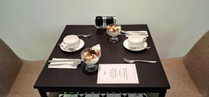 a black table with plates and wine glasses on it at Mili's B&B Guest House in Gabrovo