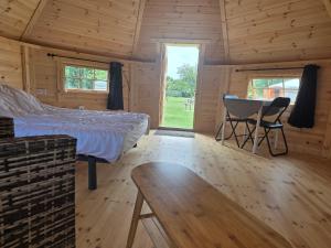 a bedroom with a bed and a table and chairs at Rando-Yourte in Paluel