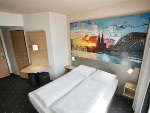 ein Schlafzimmer mit einem Bett und einem Gemälde an der Wand in der Unterkunft FlatDeCologne - Sommer in der Stadt- City Apartment Nähe DOM in Köln