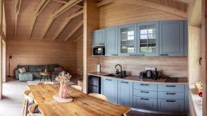 a kitchen with blue cabinets and a wooden table at Zrub Lipa, Tatry, krb a súkromie in Mengusovce