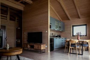 a kitchen with a television and a table with chairs at Zrub Lipa, Tatry, krb a súkromie in Mengusovce
