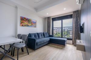 a living room with a blue couch and a window at Daylights Apart Otel in Antalya