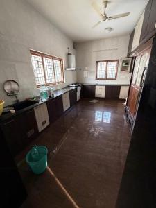 a large room with a kitchen with a ceiling at Senthur Bavanam in Udumalaippettai +2 photos