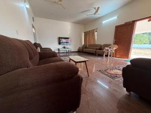 a living room with a couch and a table at Senthur Bavanam in Udumalaippettai