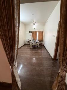 an empty living room with curtains and a table at Senthur Bavanam in Udumalaippettai