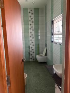 a bathroom with a toilet and a sink and a tub at Senthur Bavanam in Udumalaippettai