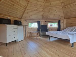 a bedroom with a bed and a desk in a cabin at Rando-Yourte in Paluel