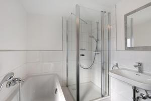 a white bathroom with a shower and a sink at Fewo Diemelrauschen in Eimelrod +34 photos