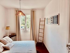 a bedroom with a ladder and a bed and a window at Maison CÔTE OUEST in Labenne +13 photos
