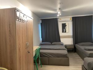 a small room with two beds and a cabinet at MAXi MaMa Room in Bangkok