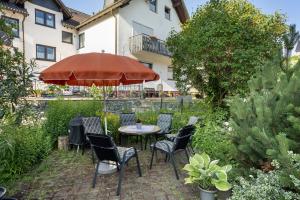 a patio with a table and chairs and an umbrella at Fewo Diemelrauschen in Eimelrod