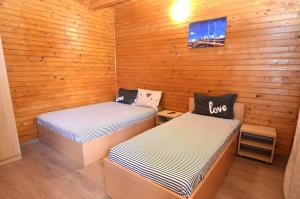 two beds in a room with wooden walls at Vila Flora Costinesti in Costinesti
