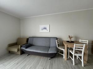 a living room with a couch and a table at Willa Relaksowa in Karwia