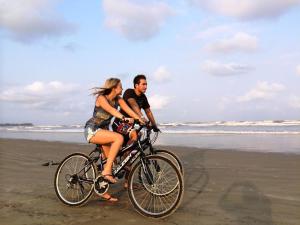a man and a woman riding a bike on the beach at Leighton Resort in Negombo