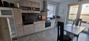 a kitchen with a counter and a table in it at VivaNatura Eifelferienappartement in Simmerath