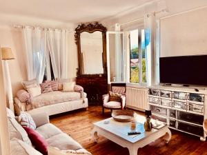 a living room with a couch and a tv at Maison CÔTE OUEST in Labenne