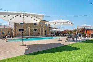 a pool with umbrellas and tables and chairs next to at Sikania Agrirelais in Caccamo
