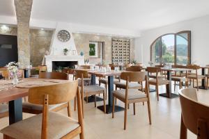 a dining room with tables and chairs and a fireplace at Sikania Agrirelais in Caccamo