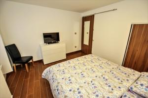 a bedroom with a bed and a tv and a chair at Apartment Old Town Square in Poreč