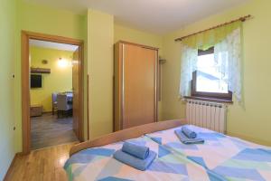 a bedroom with a bed with two blue towels on it at Apartma pod Rožem in Soča