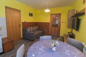 a living room with a table and a couch at Apartma pod Rožem in Soča