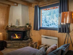 a living room with a fireplace and a window at Chalet Igel - OVO Network in Châtel +30 photos