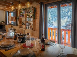 a dining room table with wine bottles and glasses at Chalet Igel - OVO Network in Châtel