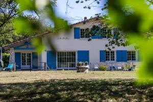 a blue and white house with a yard at Gîte du mouta in Saint-Justin