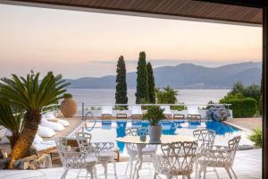 a patio with a table and chairs next to a pool at Villa Artisti Marathon in Marathon
