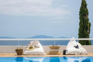 a resort with a swimming pool with towels and baskets at Villa Artisti Marathon in Marathon +82 photos