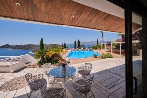 a patio with a table and chairs and a swimming pool at Villa Artisti Marathon in Marathon