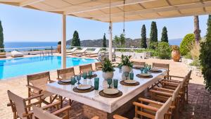 a table and chairs in front of a pool at Villa Artisti Marathon in Marathon