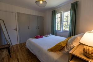 a bedroom with a large white bed and a window at Gîte du mouta in Saint-Justin
