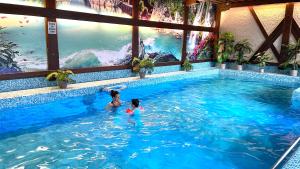 two girls swimming in a swimming pool with a mural at Haus Zellerwirt in Ruhpolding +104 photos