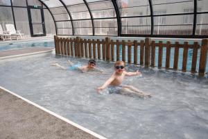 two people swimming in a swimming pool at Stella Maris in Stella-Plage