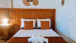 a bedroom with a bed with two towels on it at POUSADA ALLES in Santo Amaro