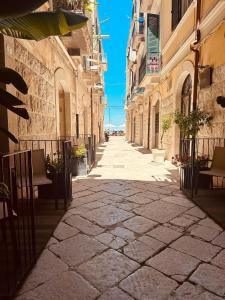 an alley in an old town with chairs and buildings at BeHome in Trani