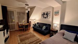 a living room with a couch and a table at Kamieniczka Elm - centrum, 100m od morza in Jastrzębia Góra
