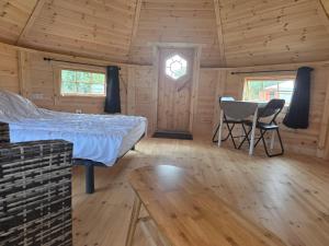 a bedroom with a bed and a table in a cabin at Rando-Yourte in Paluel
