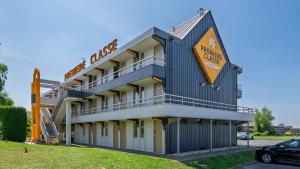 a building with a sign for a hotel at Premiere Classe Orleans Nord - Saran in Saran