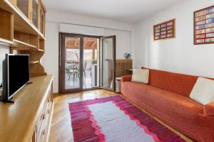 a living room with a couch and a flat screen tv at Terrazza Valtellina in Grosio