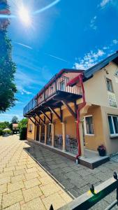 a building with a balcony on top of it at Balatonfüredi Borostyán Panzió in Balatonfüred