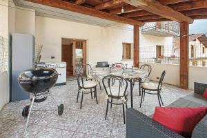 a patio with a table and chairs and a kitchen at Terrazza Valtellina in Grosio