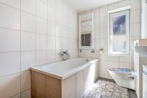 a white bathroom with a tub and a sink at Ferienwohnung bis zu 6 Per. 65 M² in Wolgast +19 photos